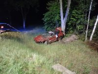samochód  rozbity stojący pomiędzy drzewami