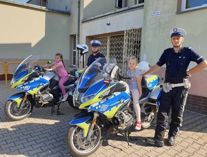 na zdjęciu widać dzieci siedzące na policyjnych motocyklach w towarzystwie policjantów