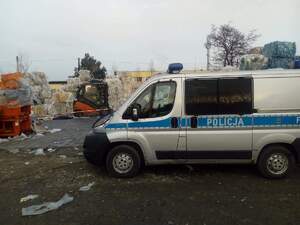 teren   zakładu  pracy  firmy w Drzewicy, w tle  taśmy odgradzające  miejsce zdarzenia na pierwszym planie radiowóz policyjny