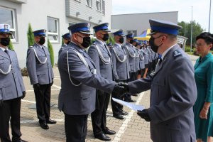 Zdjęcia z uroczystego apelu z okazji święta policji. Na dziedzińcu wewnętrznym opoczyńskiej komendy, w szeregus toją policjanci. Widać także  komendanta Powiatowego Policji, któy przyjmuje meldunek od dowódcy uroczystości a następnie przemawia do policjantów. Kolejne fotografie pokazuję przemówienia gości Wicestarosty, przedstawiciela Biura Posła na Sejm RP  oraz wójta Gm. Sławno. Na kolejnych fotografiach widać wręczanie awansów na wyższe stopnie policyjne mianowanym policjantom.