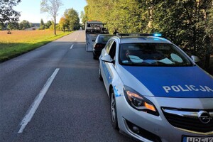 miejsce kontroli drogowej. oznakowany radiowóz policyjny, w głębi samochód ford eskort i laweta pomocy drpgpwej