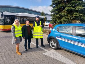 Zdjęcia przedstawiają policjantów oraz pracownika WORD podczas akcji rozdawania odblasków zarówno w klasie uczniom jak i przechodniom na ulicy. Policjanci sa umundurowani spotykają osoby piesze jak i rowerzystów Wręczają kamizelki odblaskowe oraz opaski.