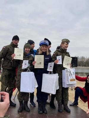 sierż. Karolina rzeźnik na podium z pucharem w mundurze oraz na podium po biegu