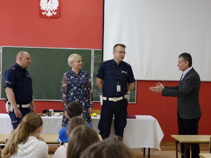 Policjanci podczas  turnieju BRD w szkole w Drzewicy. W klasie siedzą uczniowie, policjanci stoją przed nimi, Burmistrz i pracownica  urzędu  stoją obok