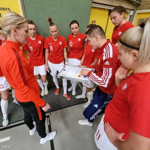 Mistrzostwa  w piłce nożnej kobiet. Drużyna policjantek podczas zawodów. Trening, biegają po hali, odbierają puchar, zdjęcia grupowe zawodniczek