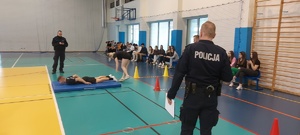 eliminacje powiatowe konkursu. Hala sportowa, zawodnicy ze szkół, stoją takze przedstawiciele władz samorządowych, kierownictwo policji, policjanci,  w tle widać stół z nagrodami oraz banery policji