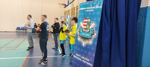 eliminacje powiatowe konkursu. Hala sportowa, zawodnicy ze szkół, stoją takze przedstawiciele władz samorządowych, kierownictwo policji, policjanci,  w tle widać stół z nagrodami oraz banery policji