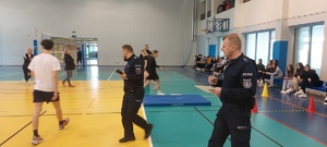 eliminacje powiatowe konkursu. Hala sportowa, zawodnicy ze szkół, stoją takze przedstawiciele władz samorządowych, kierownictwo policji, policjanci,  w tle widać stół z nagrodami oraz banery policji