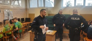 eliminacje powiatowe konkursu. Hala sportowa, zawodnicy ze szkół, stoją takze przedstawiciele władz samorządowych, kierownictwo policji, policjanci,  w tle widać stół z nagrodami oraz banery policji