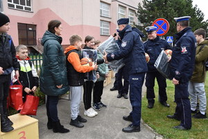 Policjanci podczas turnieju BRD z uczniami  na placu podczas jazdy rowerem oraz podczas wręczania nagród.