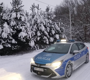 oznakowany radiowóz na ośnieżonej drodze