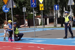 policjanci z dziećmi podczas zajęć w miasteczku ruchu drogowego w Opocznie.