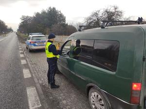 policjantka stoi przy samochodzie ciężarowym, radiowóz policyjny.