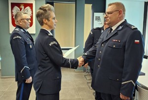 policjantka w mundurze podaje rękę policjantowi w mundurze.