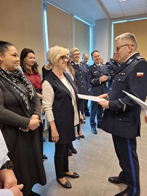 policjant w mundurze, grupa ludzi wokół niego.