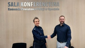 policjantka i mężczyzna podają sobie rękę.