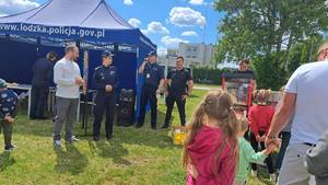policjanci rozmawiają z ludźmi, namiot.