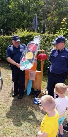 dwóch policjantów rozmawia z dziećmi.