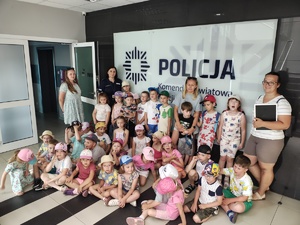 kobiety, policjantka stoją na korytarzu budynku, na ścianie napis policja.