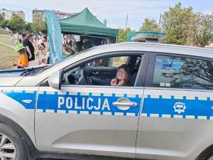 dziecko siedzi w radiowozie policyjnym.