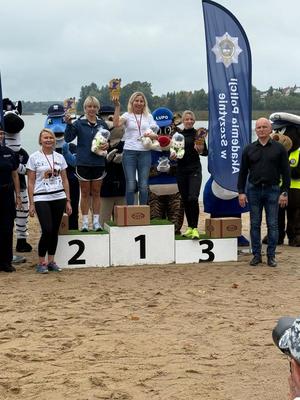 trzy kobiety stoją na podium, jedna obok, mężczyzna stoi obok podium.