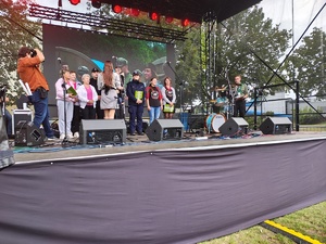 policjantka i kilka osób stoją na scenie.