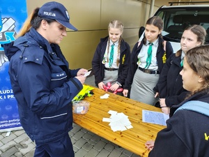 policjantka trzyma w ręku karteczkę, harcerze.