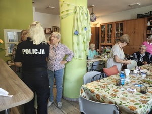 policjantka rozmawia ze starszymi osobami.