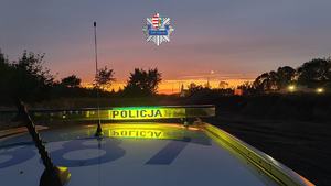 logo policji, napis policja, zachód słońca.