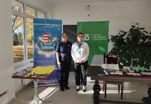 policjantka, kobieta, za nimi napisy policja, zus.
