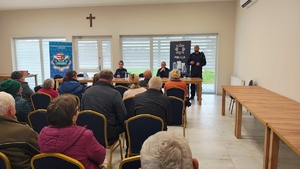 policjant w mundurze stoi przed grupą ludzi.