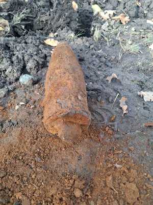 przedmiot przypominający pocisk, leży na ziemi.