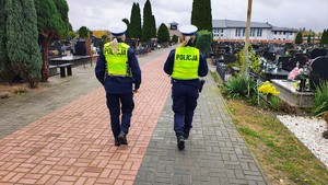 dwie policjantki idą na cmentarzu.