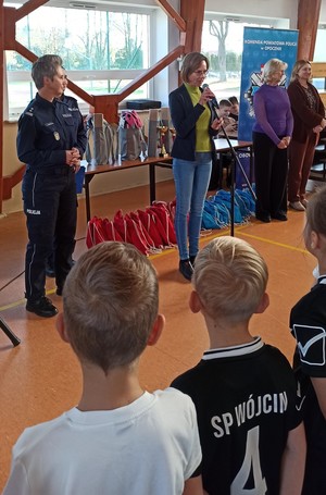 policjantka, dwie kobiety, dzieci stoją tyłem.