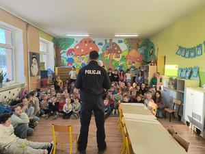 policjant stoi przed dziećmi w klasie.