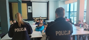 policjantka i policjant znajdują się w pomieszczeniu z dziećmi.