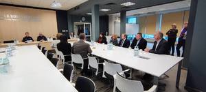 widok sali konferencyjnej , przy stołach siedzą kobiety i mężczyźni, osoby w mundurach, na ścianie widoczny napis sala konferencyjna komendy powiatowej policji w Opocznie.