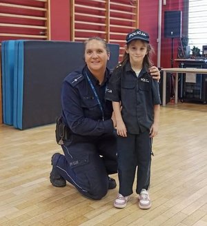 policjantka z dziewczynką ubraną w strój policjanta.