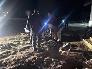 mężczyźni stoją porą wieczorową, widoczne niebieskie światło.