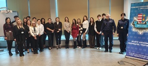 grupa ludzi, policjanci stoją w sali, obok napis komenda powiatowa policji w Opocznie.