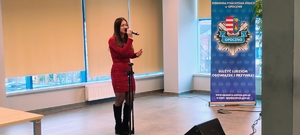 młoda kobieta w czerwonej sukience trzyma mikrofon.