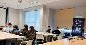 młodzież siedzi na sali konferencyjnej, obok baner z napisem policja.
