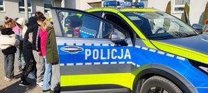 dzieci oglądają radiowóz policyjny.