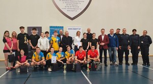 policjanci, młodzież w sportowych strojach, kobiety i mężczyźni stoją na sali gimnastycznej.