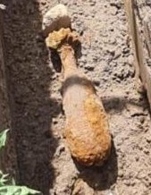 pocisk w kolorze brązowym leży w ziemi.