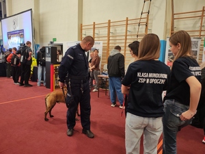 policjant z psem stoi przed dziewczynami w koszulkach z napisem klasa mundurowa.