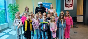 grupa dzieci, policjanta i policjant, kobiety stoją w sali komendy powiatowej policji w Opocznie.