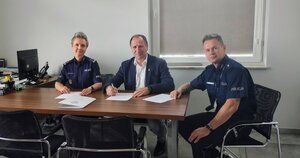 cztery osoby siedzą przy stole, w tym policjant i policjantka.