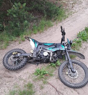 motocykl typu cross leży na polnej drodze.