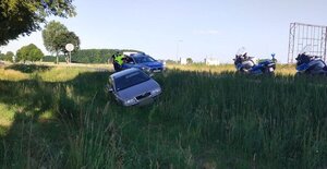 na zdjęciu widoczny samochód który wjechał do rowu, za nim policjanci, radiowóz i motocykle.
